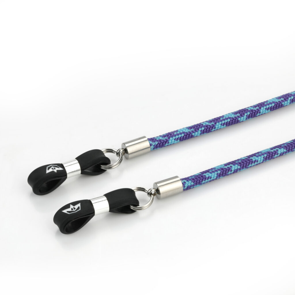 Zdjęcie produktowe: niebiesko-fioletowy sznureczek Necks, zbliżenie na detal. Na końcówkach sznurka zastosowano elastometr i srebrne zaciski.